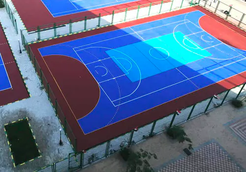 Açık hava basketbol sahasında kırmızı ve mavi akrilik kaplı sert zemin