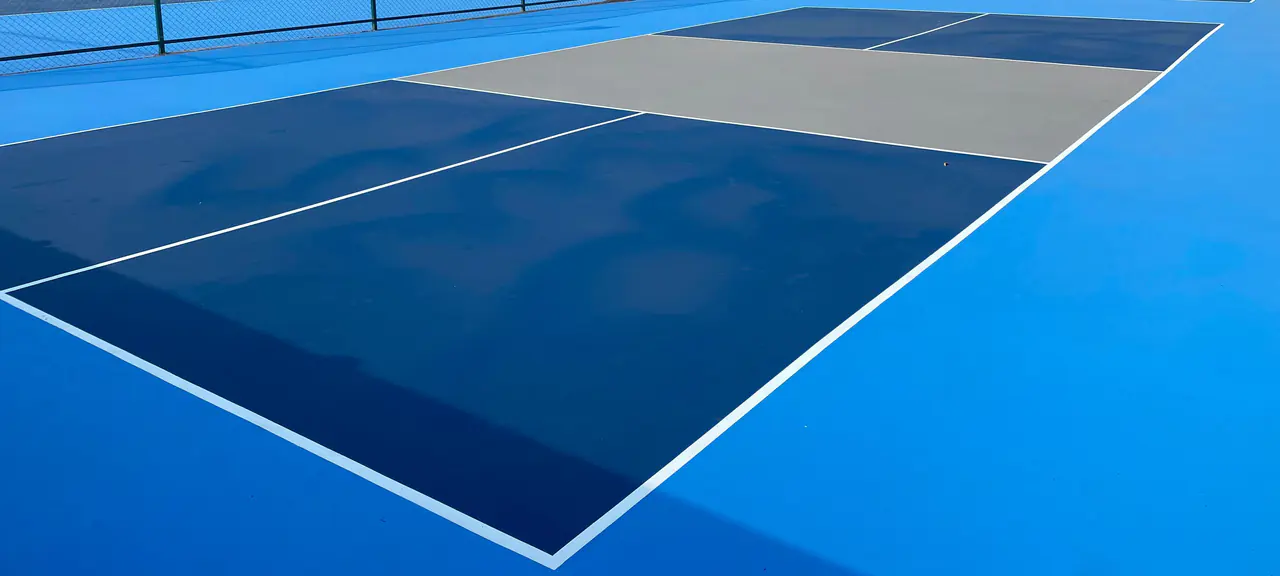 Mavi akrilik kaplamalı tenis kortunun yüzeyi ve beyaz oyun çizgileri